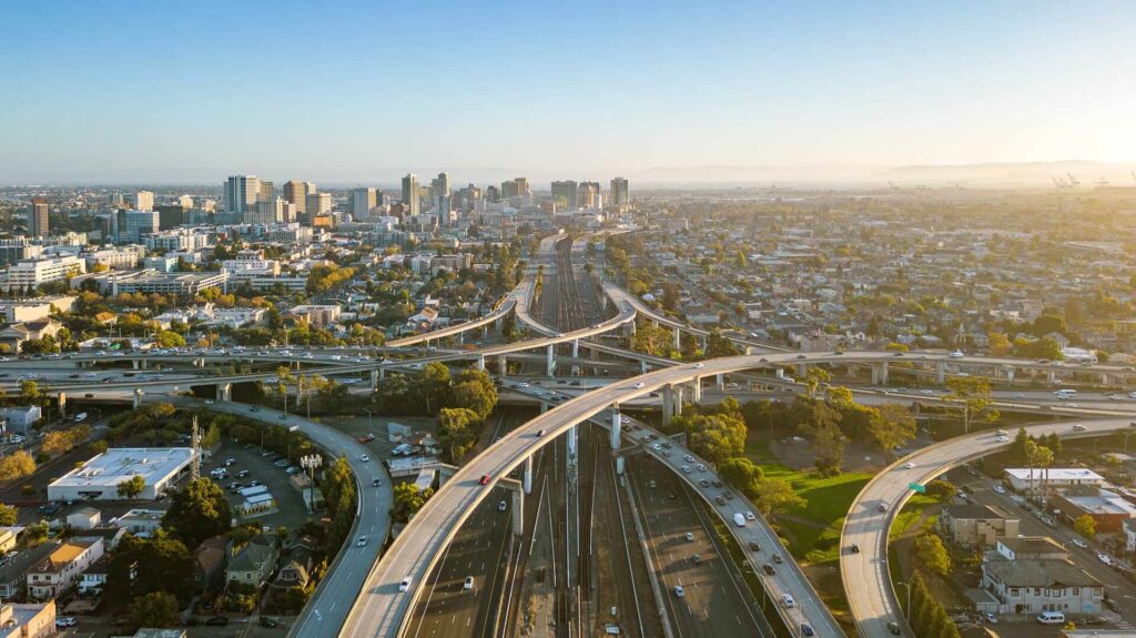 A drone view over the freeway cypress in Oakland, California during sunset with the downtown in the background - Lemon Law Attorney in Oakland, California